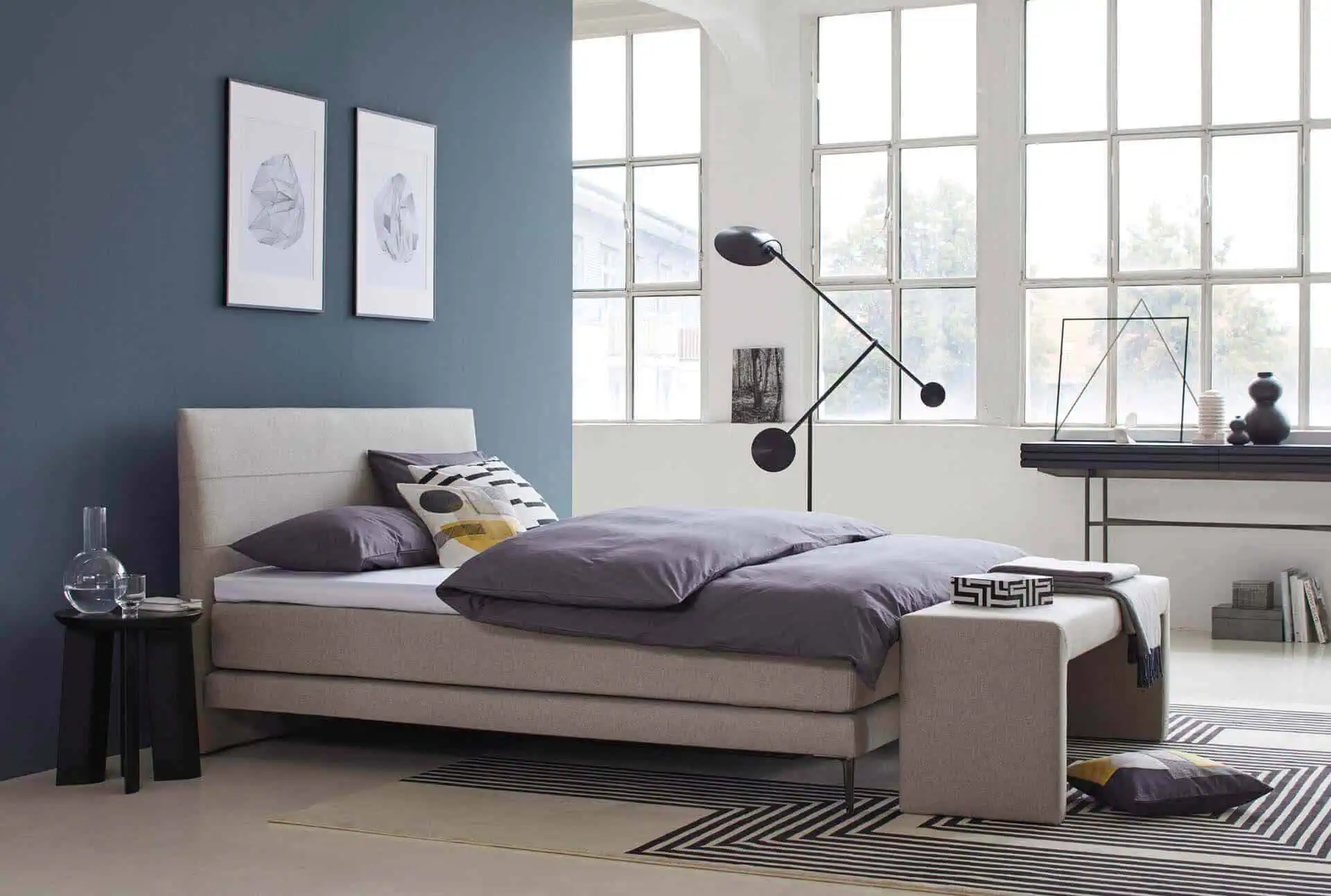 Isabelle by Bico Boxspring Bett Kopfteil Legend im Schlafzimmer mit Kissen und Decke dekoriert Bank vor Bett Stoff